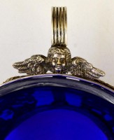 cca 1900 Puttós díszítésű, füles kínáló tál kék üvegbetéttel (hibátlan). ezüstözött áttört fém  / Silver plated metal tray with glass d: 16 cm