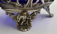 cca 1900 Puttós díszítésű, füles kínáló tál kék üvegbetéttel (hibátlan). ezüstözött áttört fém  / Silver plated metal tray with glass d: 16 cm