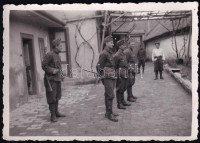 1941 Szabadka (Subotica), Vajdaság, magyar katonák egy ház udvarán, egyikük szuronyos puskával, II. világháborús fotó, a hátoldalon feliratozva, 8,5x6 cm